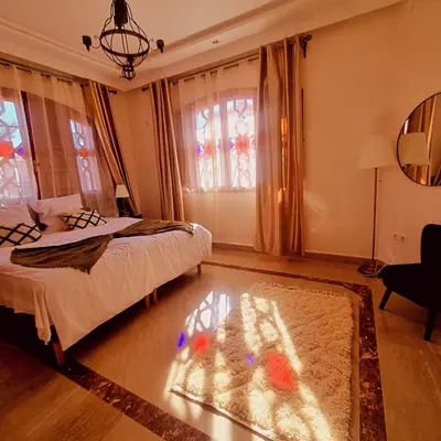 a bedroom with a bed and a glass table at Zine Villa Guest House in Marrakech