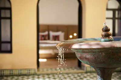 a water fountain in a room with a bedroom at Dar Banati Palmeraie in Marrakech