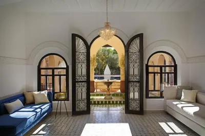 a living room with two blue couches and two windows at Dar Banati Palmeraie in Marrakech