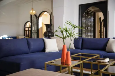 a living room with a blue couch and a table at Dar Banati Palmeraie in Marrakech