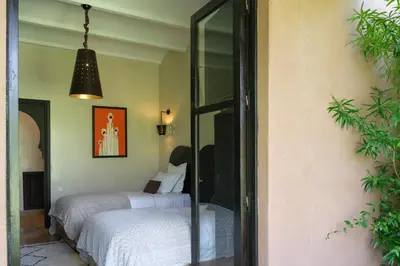 a bedroom with two beds and a pendant light at Villa Jennabelle in Marrakech