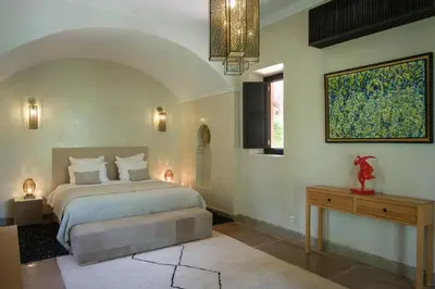 a bedroom with a bed and a table and a window at Villa Jennabelle in Marrakech