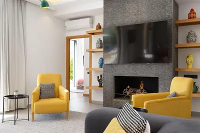 a living room with yellow chairs and a fireplace at ADA ADA modern villa with heated private pool next city center in Marrakech