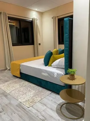 a bedroom with a large bed with blue and yellow pillows at Villa Amèle,calme,Ensoleillé,Piscine,Salle de jeux in Marrakech