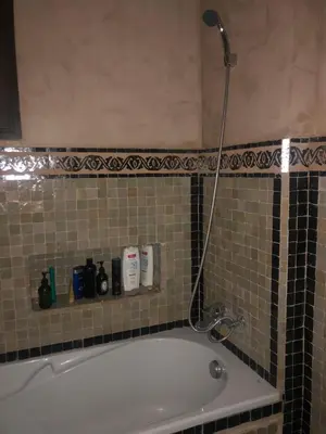 a bathroom with a bath tub with a shower at Appartement paisible et abordable Palmeraie Marrakech in Dar Caïd Layadi