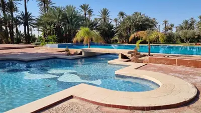 a large swimming pool with a resort style swimming pool at Appartement paisible et abordable Palmeraie Marrakech in Dar Caïd Layadi