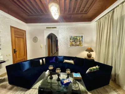 a blue couch in a living room with a table at Au Temps Des Fleurs - Marrakech in Marrakech