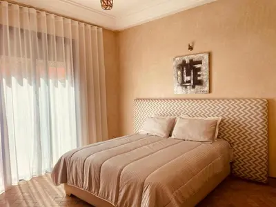 a bedroom with a bed and a large window at Villa Talmoulkt Familiale in Marrakech