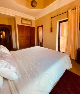 a large white bed in a room with a window at Villa Talmoulkt Familiale in Marrakech