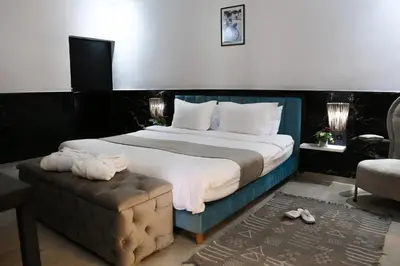 a bedroom with a large bed and a chair at Luxury heated pool Villa Marrakech in Marrakech