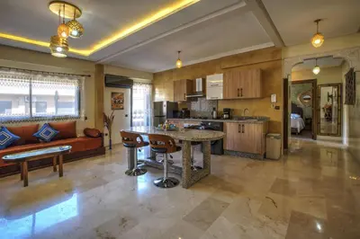 a large kitchen with a table and a couch at Nour 5 el bellar in Marrakech