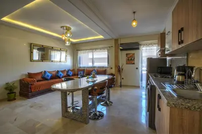 a kitchen and living room with a couch and a table at Nour 5 el bellar in Marrakech