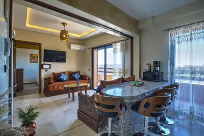 a living room with a bed and a table and chairs at Nour 5 el bellar in Marrakech