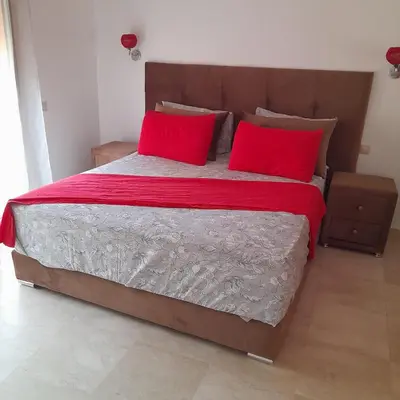 a bedroom with a large bed with red pillows at appartement génial in Marrakech