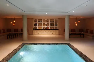 a large indoor pool in a room with columns at Maison Kenoosha Boutique Hotel & Spa in Marrakech