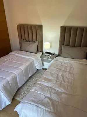 two beds sitting next to each other in a bedroom at Beautiful apartment in Golf City Marrakech in Marrakech