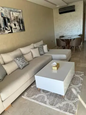 a living room with a couch and a coffee table at Beautiful apartment in Golf City Marrakech in Marrakech