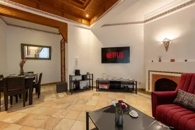 a living room with a red couch and a fireplace at Appartement de luxe à Palmeraie Village 2 in Marrakech
