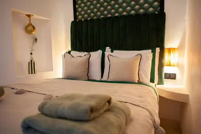 a bedroom with a large bed with a green headboard at Cosy Riad in Marrakech