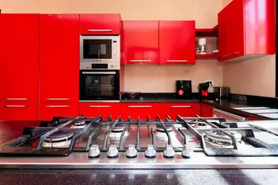 a kitchen with red cabinets and a stove top oven at Villa les Palmiers in Marrakech
