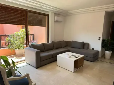 a living room with a couch and a coffee table at APPARTEMENT JAWHARA HIVERNAGE in Marrakech