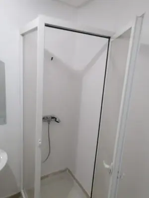 a shower with a glass door in a bathroom at Nic's apartment in Marrakech