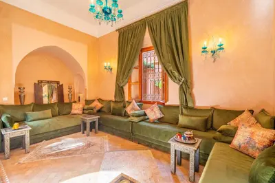 a living room with a green couch and tables at Villa les oliviers in Marrakech
