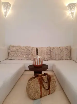 a lamp on a table in front of a couch at Riad Nour, Maison de charme. in Marrakech