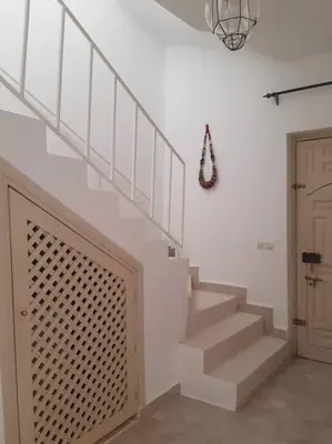 a staircase in a white room with a door at Riad Nour, Maison de charme. in Marrakech