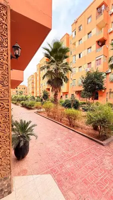a courtyard with palm trees and a building at WOLFY’s Apartment in Marrakech