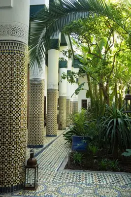 a courtyard of a building with columns and plants at Palais Riad Lamrani in Marrakech
