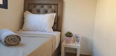 a bedroom with a bed with a pillow and a table at Appartement gueliz 2 chambres in Marrakech