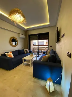 a living room with a blue couch and a table at Appartement gueliz 30 in Marrakech