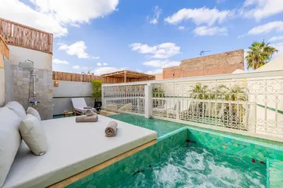 a villa with a swimming pool and a balcony with a bed at Riad Agan Exclusive with New Heated Pool and Breakfast included in Marrakech