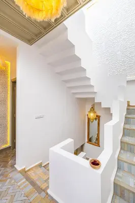a white staircase in a room with white walls and a mirror at Riad Zahra b&b your private house in Marrakech in Marrakech
