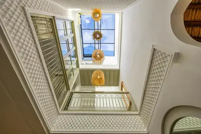 a stairway with two windows and a stair case at Riad Zahra b&b your private house in Marrakech in Marrakech