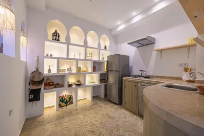 a kitchen with white walls and white shelves with food items at Riad Zahra b&b your private house in Marrakech in Marrakech