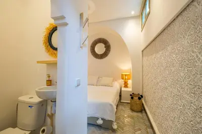 a white bathroom with a bed and a sink at Riad Zahra b&b your private house in Marrakech in Marrakech