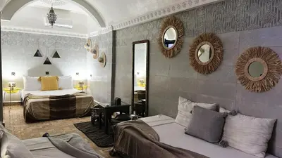 a bedroom with two beds and mirrors on the wall at RIAD MAMAHOUSE in Marrakech
