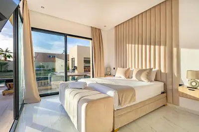 a bedroom with a large bed and a large window at Villa Victoria, piscine Chauffée, sans vis à vis in Marrakech