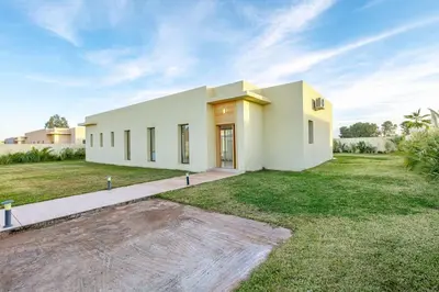 a large white house with a large yard at Villa Victoria, piscine Chauffée, sans vis à vis in Marrakech
