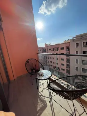 a balcony with two chairs and a glass table at Appartement 2 ch in Marrakech