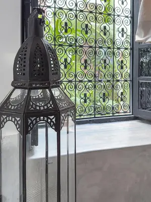 a black lamp sitting in front of a window at Riad Atay in Marrakech