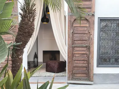 an open door in a house with a palm tree at Riad Atay in Marrakech