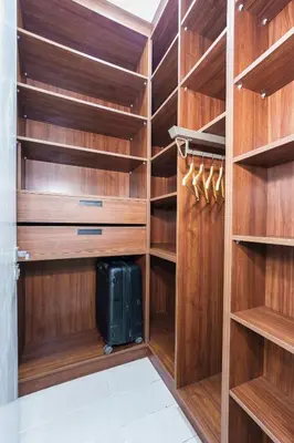 a walk in closet with wooden shelves and a suitcase at Les Palmier de targa, Romantic appartement in Marrakech