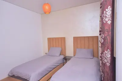a small room with two beds and a lamp at Appartement Prestigia Golf City Marrakech in Marrakech