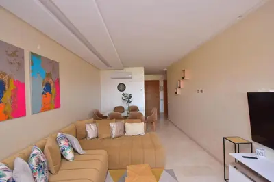 a living room with a couch and a flat screen tv at Appartement Prestigia Golf City Marrakech in Marrakech
