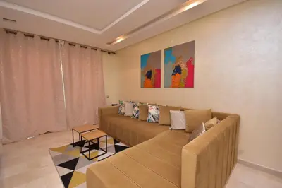 a living room with a couch and a table at Appartement Prestigia Golf City Marrakech in Marrakech