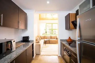 a kitchen with a refrigerator and a living room at Duplex Majorelle Marrakech in Marrakech