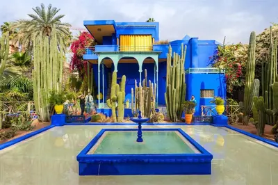 a blue building with a fountain in the middle of a pool at Duplex Majorelle Marrakech in Marrakech